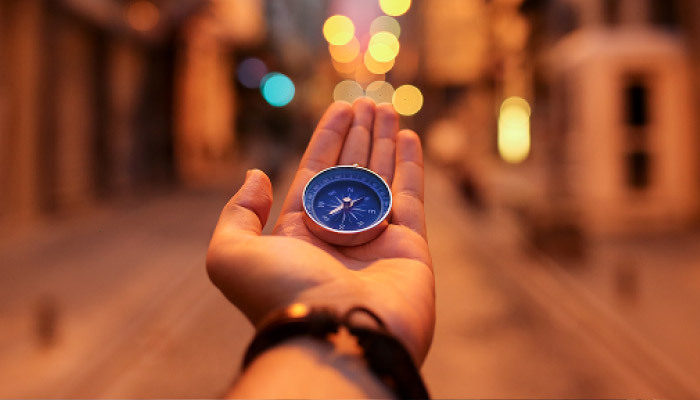 Hand holding a compass